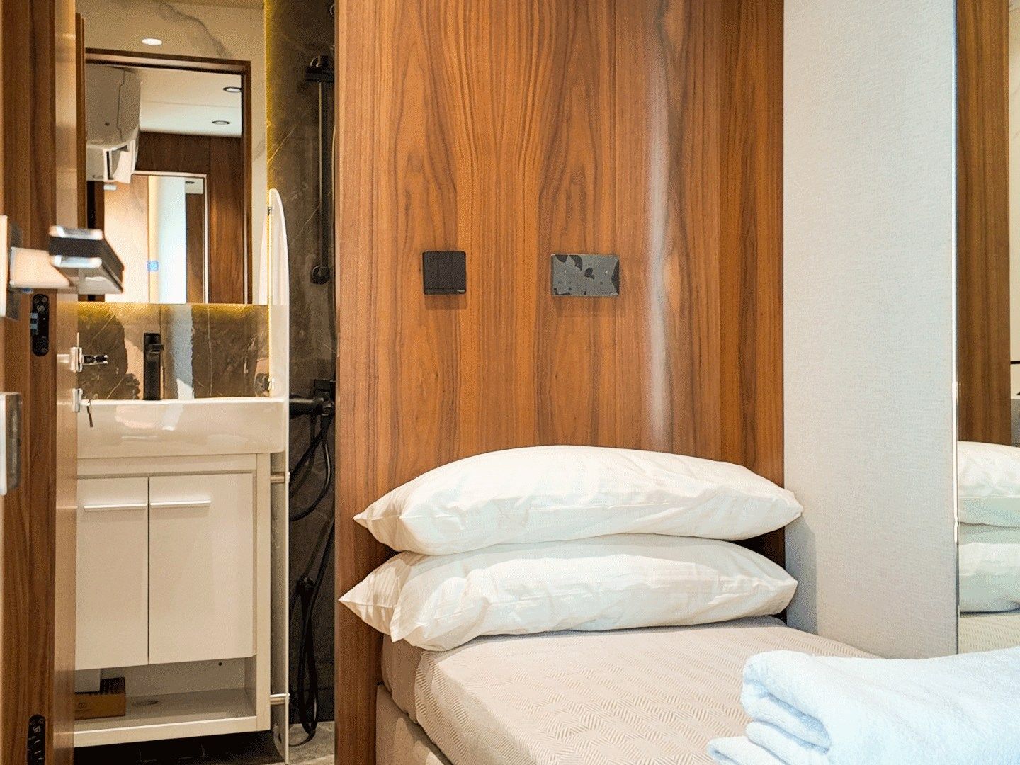 NERO 75 captain's cabin with a single bed, timber panelling and its own bathroom